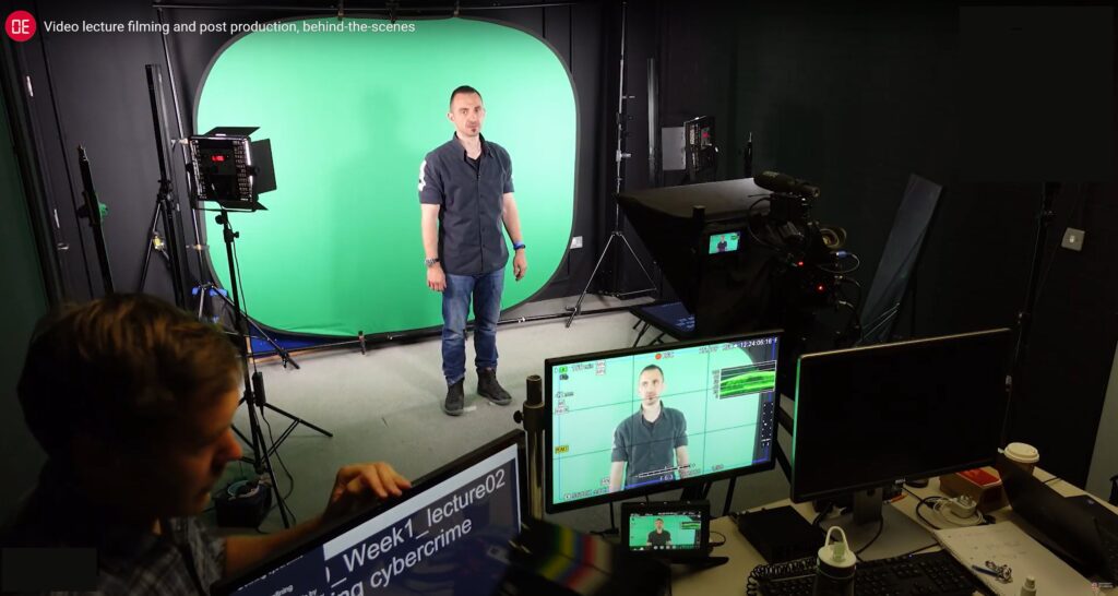 A man in a filming studio standing in front of a green screen