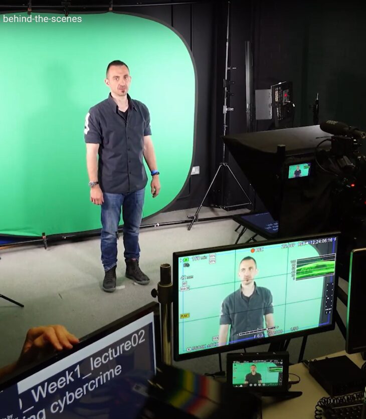 A man in a filming studio standing in front of a green screen